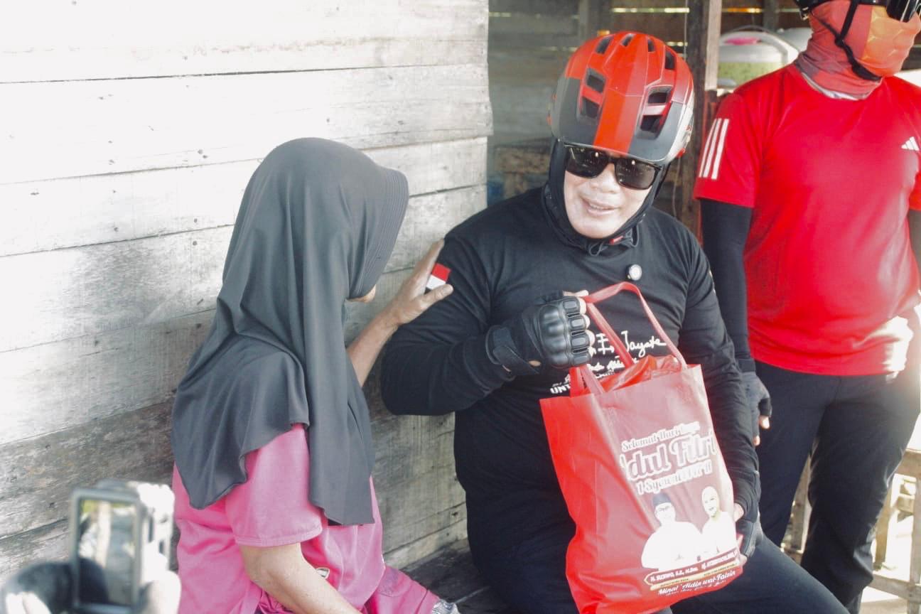 Bupati Kubu Raya Sujiwo menyerahkan sembako kepada warga saat kegiatan gowes