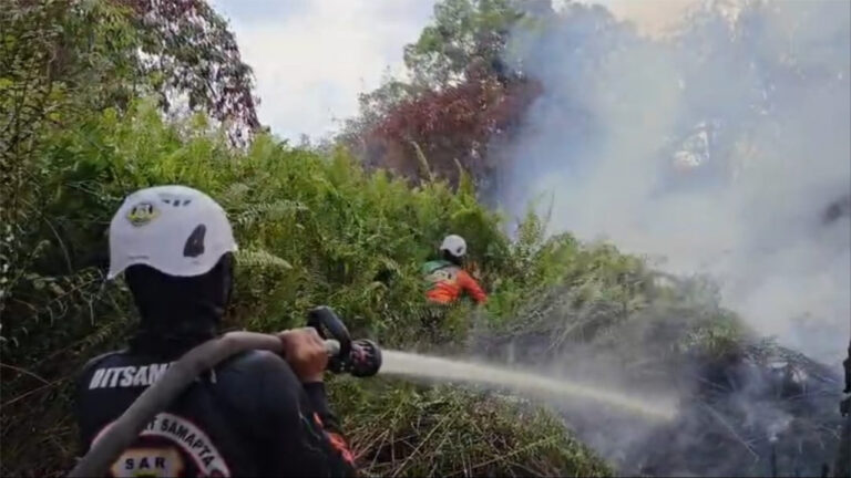 Petugas Tim SAR Ditsamapta Polda Kalbar menyemprotkan air ke titik api karhutla di semak belukar. (Dok. HO/NusantaraPost)