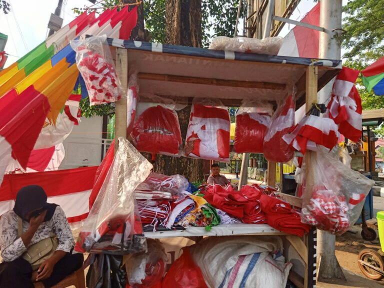 "Pedagang bendera musiman di Pontianak keluhkan sepinya pembeli jelang HUT ke-81 RI. Omzet merosot imbas tren belanja daring dan minimnya instruksi perayaan RT."