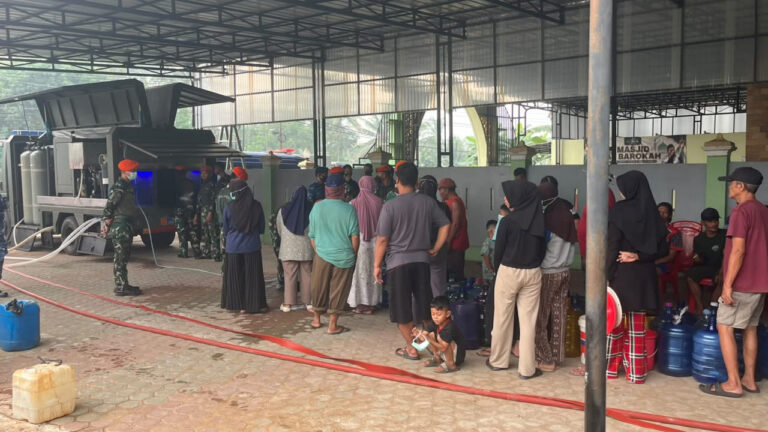 Prajurit Yon Parako 466 Pasgat melayani warga Desa Kuala Dua yang mengantre air siap minum dari Truk Water Treatment. (Dok. HO/Nusantara Post)