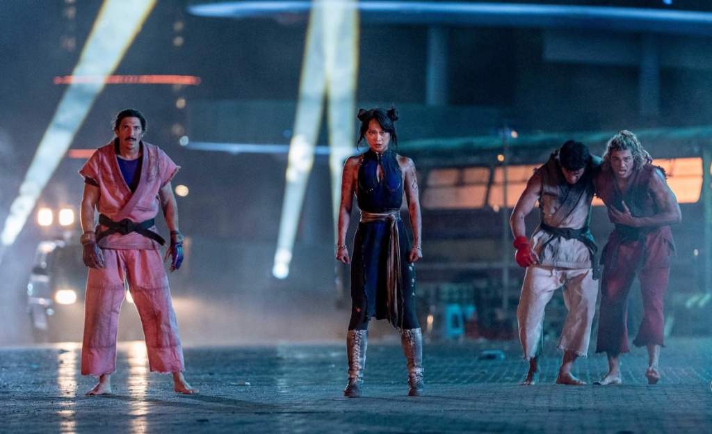 Callina Liang sebagai Chun-Li berdiri bersama para aktor pemeran petarung dalam adegan film Street Fighter.