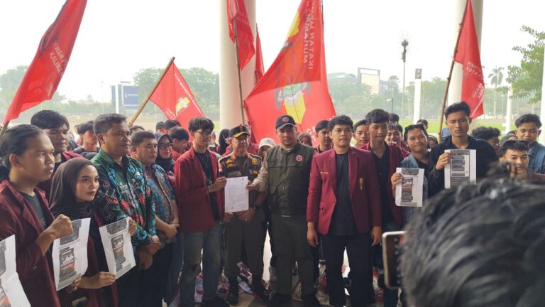 Puluhan mahasiswa berjaket merah membawa bendera IMM dan cetakan pesan dalam aksi di Pontianak, Jumat (9/10/2026).