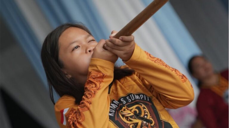 Peserta perempuan mengenakan kaos seragam kuning membidik sasaran dengan menyumpit dalam ajang Lomba Sumpit KORMI Kaltara. (Dok. Facebook/DKISP Kaltara)