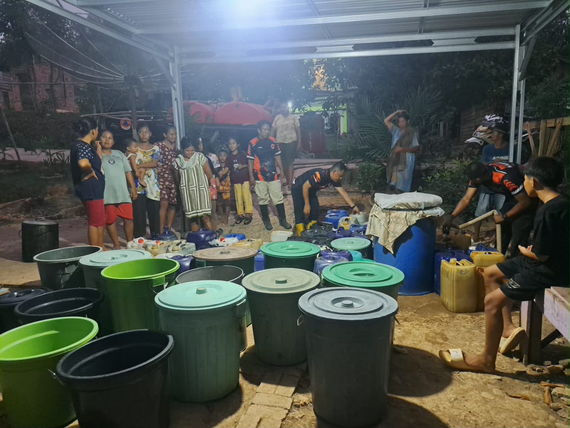 Warga di Muara Enim mengumpulkan ember dan drum di malam hari untuk bantuan air bersih