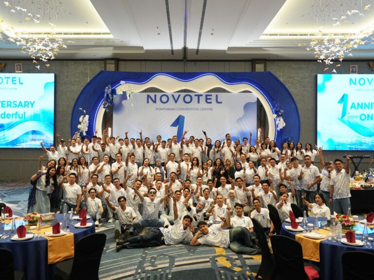 Manajemen dan staf Novotel Pontianak berfoto bersama dengan pose pose angka satu di panggung acara.
