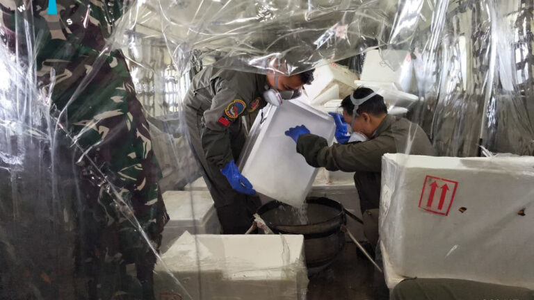 Petugas TNI dan tim teknis menuangkan butiran dry ice ke corong penabur di dalam kabin pesawat operasi modifikasi cuaca. (Dok. HO/Nusantara Post)