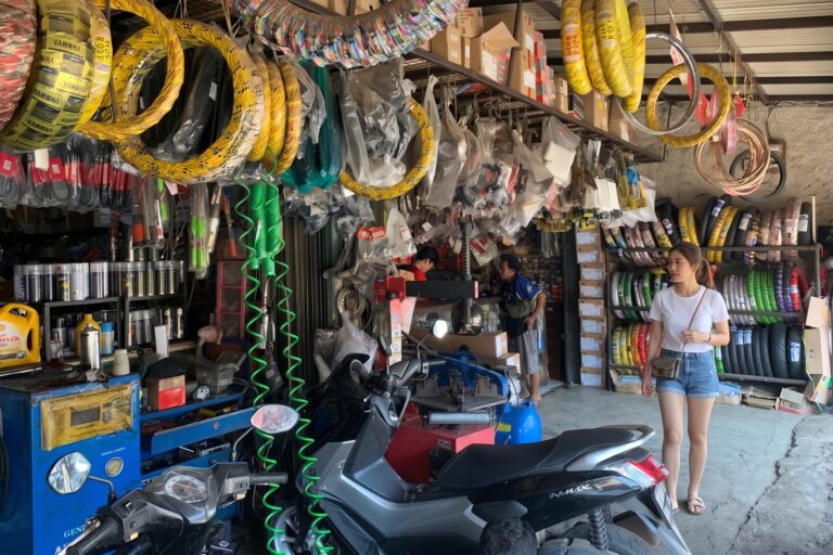 Kondisi bagian dalam bengkel sepeda motor yang dipenuhi ban dan suku cadang
