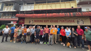 Wisatawan senior Singapura berfoto di depan Warung Kopi Asiang Pontianak. (Dok. Ist)